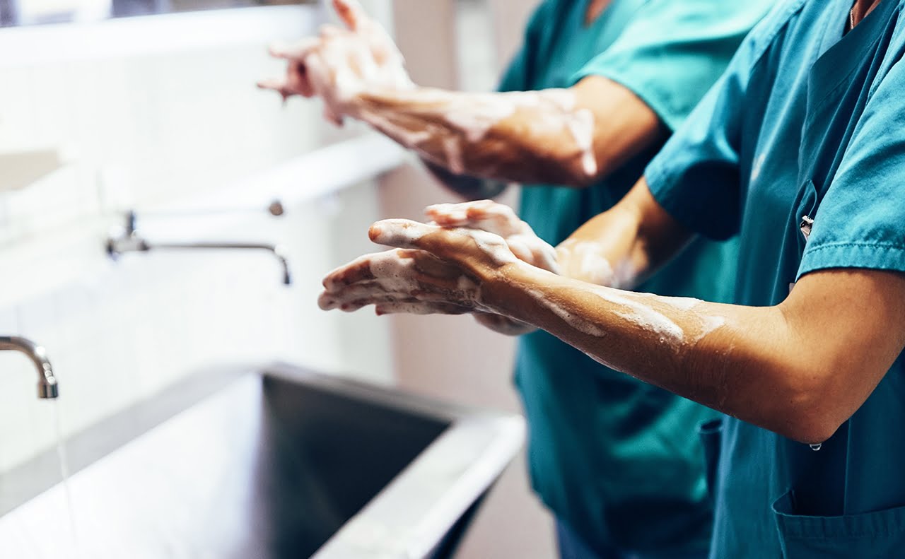 Surgeons washing hands before handling the patient.